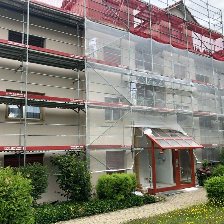 Eingerüstetes Mehrfamilienhaus während des Fassadenanstrichs
